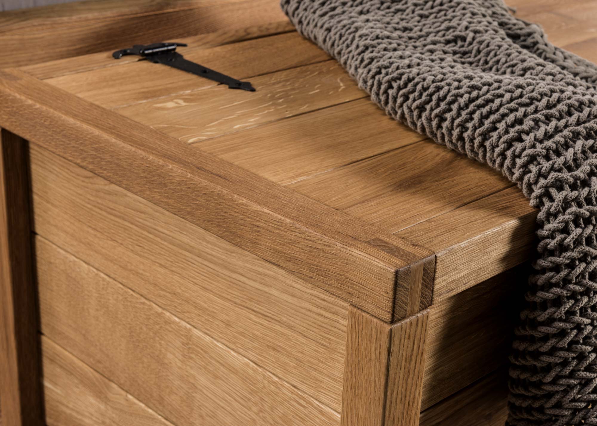 Zamknięta drewniana skrzynia z miękkim pledem na wierzchu