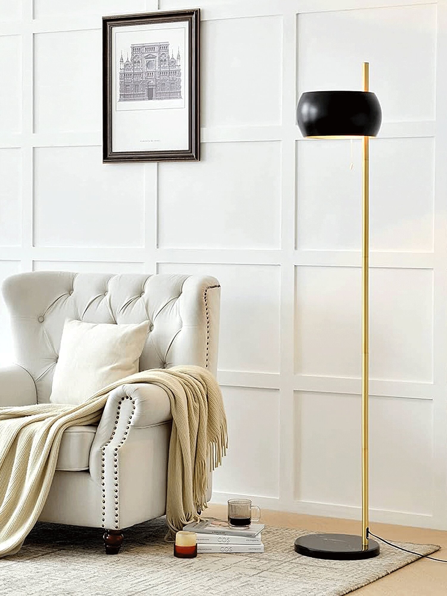 Fotel i złota lampa stojąca przy ścianie z dekoracyjnymi panelami