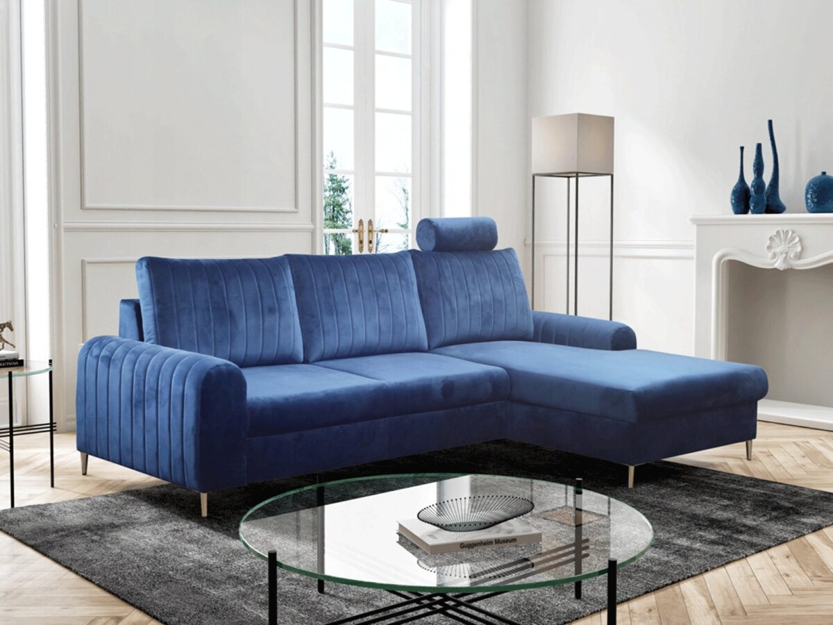 Narożnik z niebieską tapicerką i szklanym stolikiem w jasnym salonie