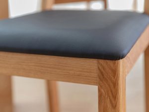 Miniaturka 5 - Detal siedziska z czarnej tapicerki i litego dębu