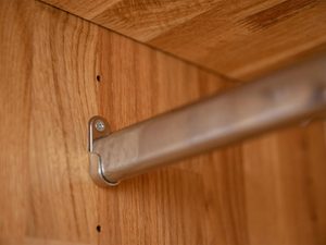 Miniaturka 1 - Detal drążka na ubrania w drewnianej szafie z wieszakiem