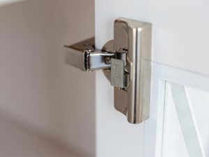 Miniaturka 2 - Zawias metalowy zamontowany w drewnianym boku witryny