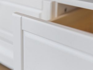 Miniaturka 4 - Zaokrąglony bok białej szafki z klasycznym frezowaniem