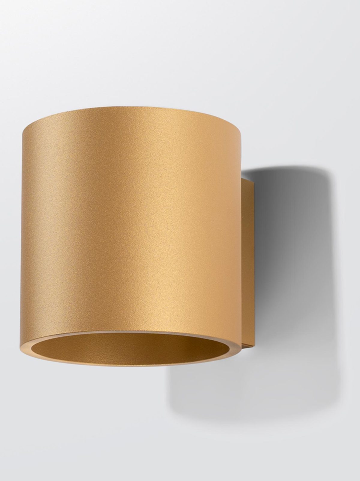 Lampa walec złota zamontowana na białej ścianie Lampa walec złota zamontowana na białej ścianie