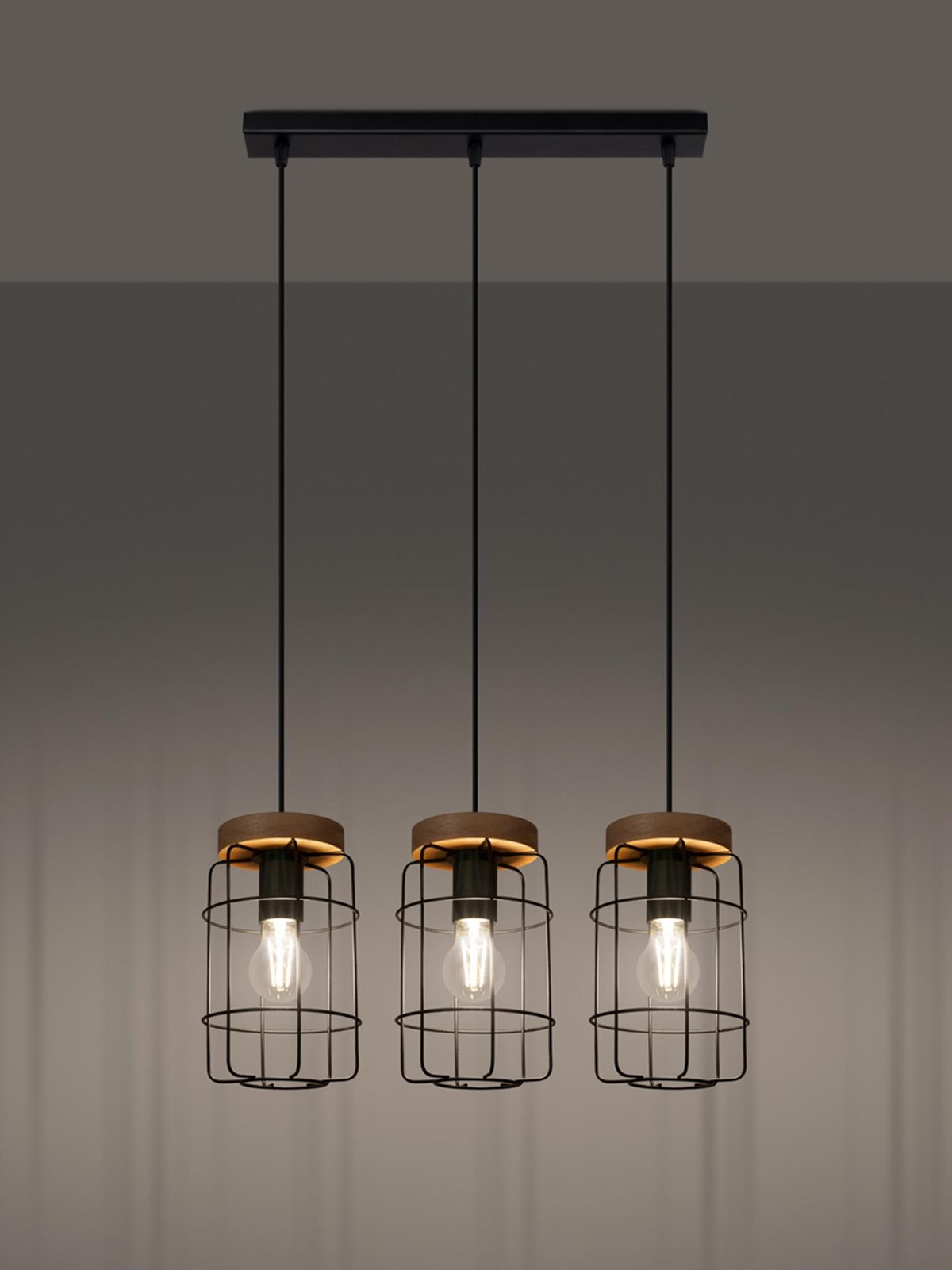 Trzy lampy wiszące z metalowymi siatkami w loftowym wnętrzu