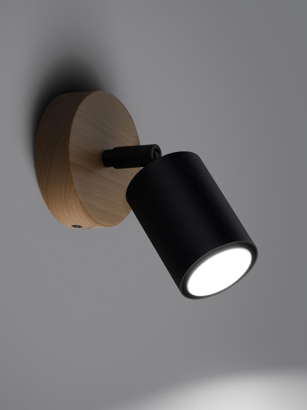 Czarny reflektor LED na okrągłej bazie ze sklejki, montowany na ścianie