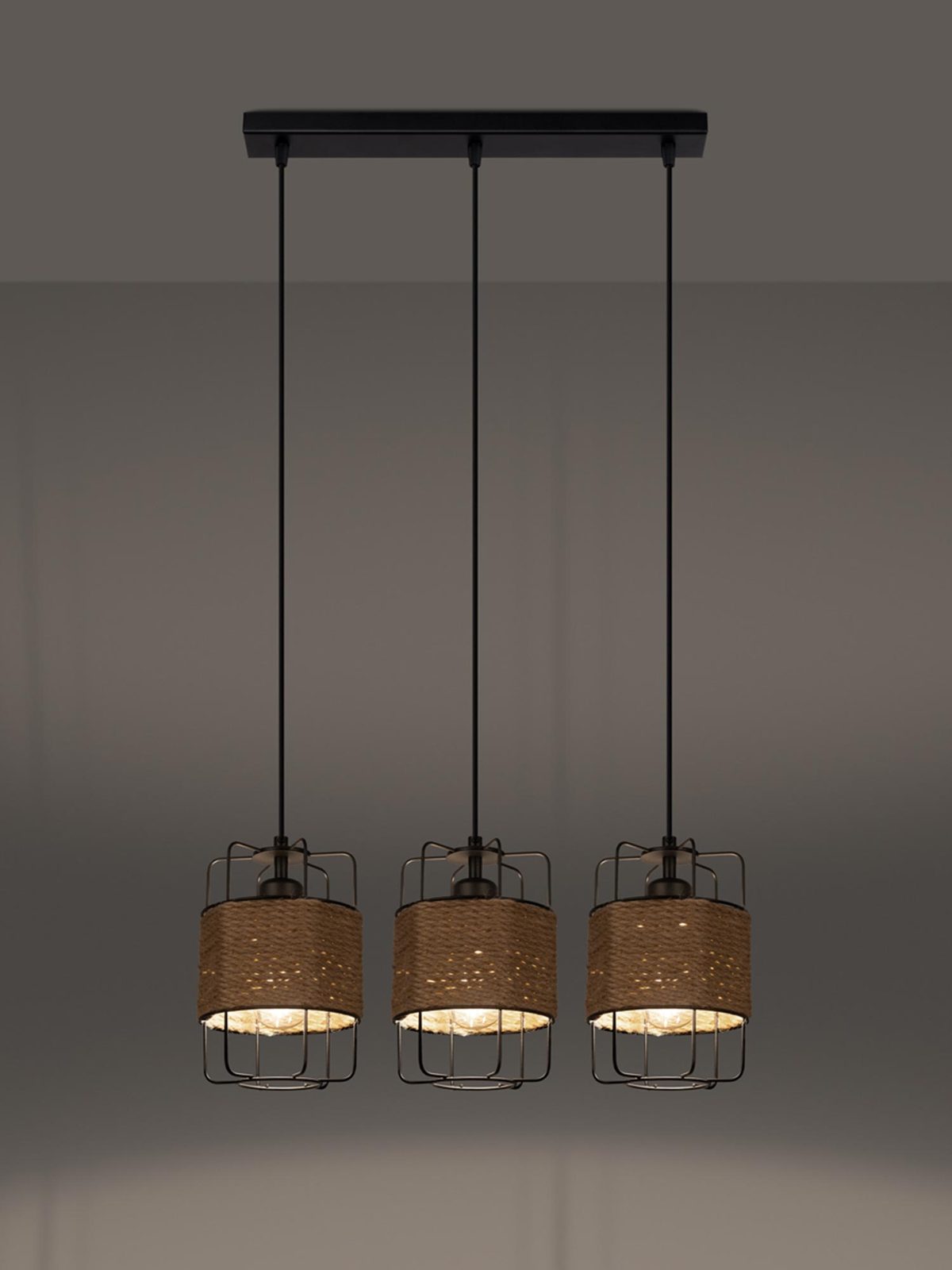 Trzy lampy z plecionym kloszem w wieczornym świetle