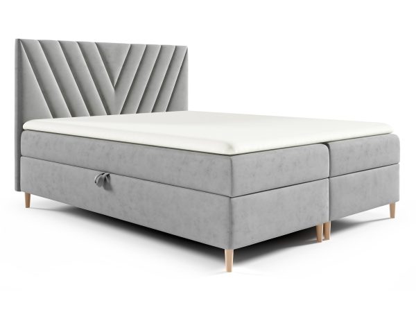 Łóżko tapicerowane w jasnoszarym kolorze z geometrycznym pikowaniem