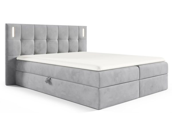 Łóżko tapicerowane w jasno szarym kolorze z pikowanym zagłówkiem