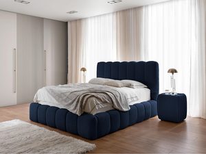 Miniaturka 15 - Granatowe łóżko z tekstylną narzutą, w eleganckim wnętrzu z beżowymi zasłonami.