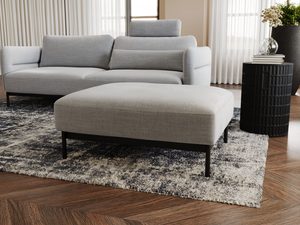 Miniaturka 18 - Puf w kolorze popielatym ustawiony przy sofie narożnej