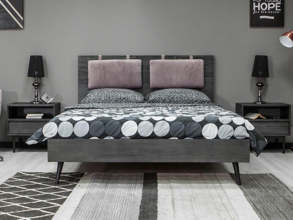 Stylowe łóżko w ciemnych odcieniu w industrialnym wnętrzu