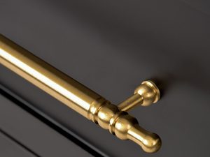 Miniaturka 5 - Zbliżenie na elegancki złoty uchwyt w stylu vintage na meblach z wiązu