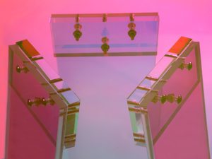 Miniaturka 1 - Zbliżenie na nogi kolorowego stolika szklanego z metalowymi mocowaniami