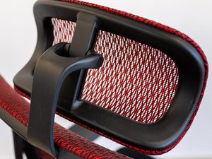 Miniaturka 1 - Fotel biurowy ergonomiczny detal czerwonego zagłówka siatkowego zbliżenie