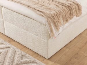 Miniaturka 11 - Detal kremowej podstawy łóżka tapicerowanego w boucle