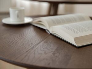Miniaturka 10 - Stolik kawowy dębowy z otwartą książką i filiżanką kawy
