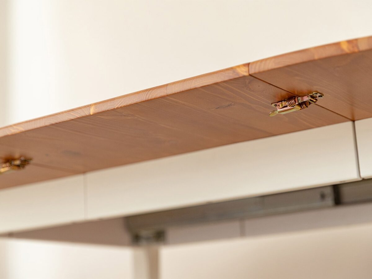 Detal mechanizmu blokady blatu stołu rozkładanego z zatrzaskami pod spodem