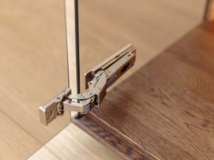 Miniaturka 12 - Detal dolnego narożnika witrynki szklanej highboardu tabacco z usłojeniem