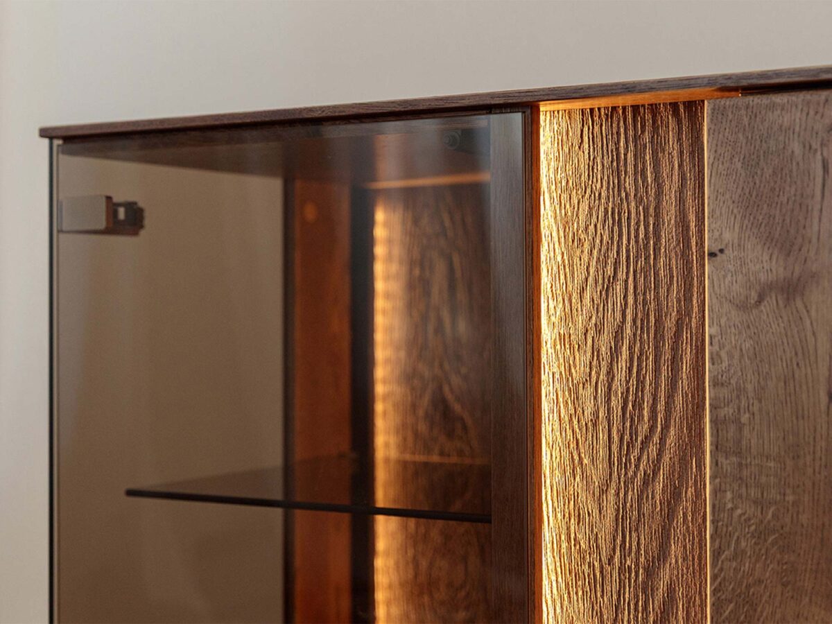 Detal drzwi dębowych highboardu z metalowym uchwytem i podświetleniem LED