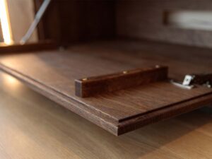 Miniaturka 3 - Detal otwartej klapy komody tabacco z drewnianym uchwytem i podświetleniem LED