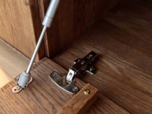 Miniaturka 4 - Detal zawiasu i siłownika gazowego klapy komody tabacco zbliżenie