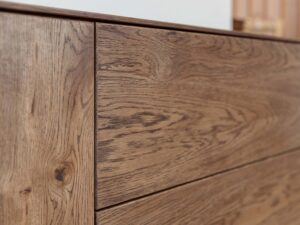 Miniaturka 5 - Detal frontów szuflad komody tabacco z usłojeniem drewna zbliżenie