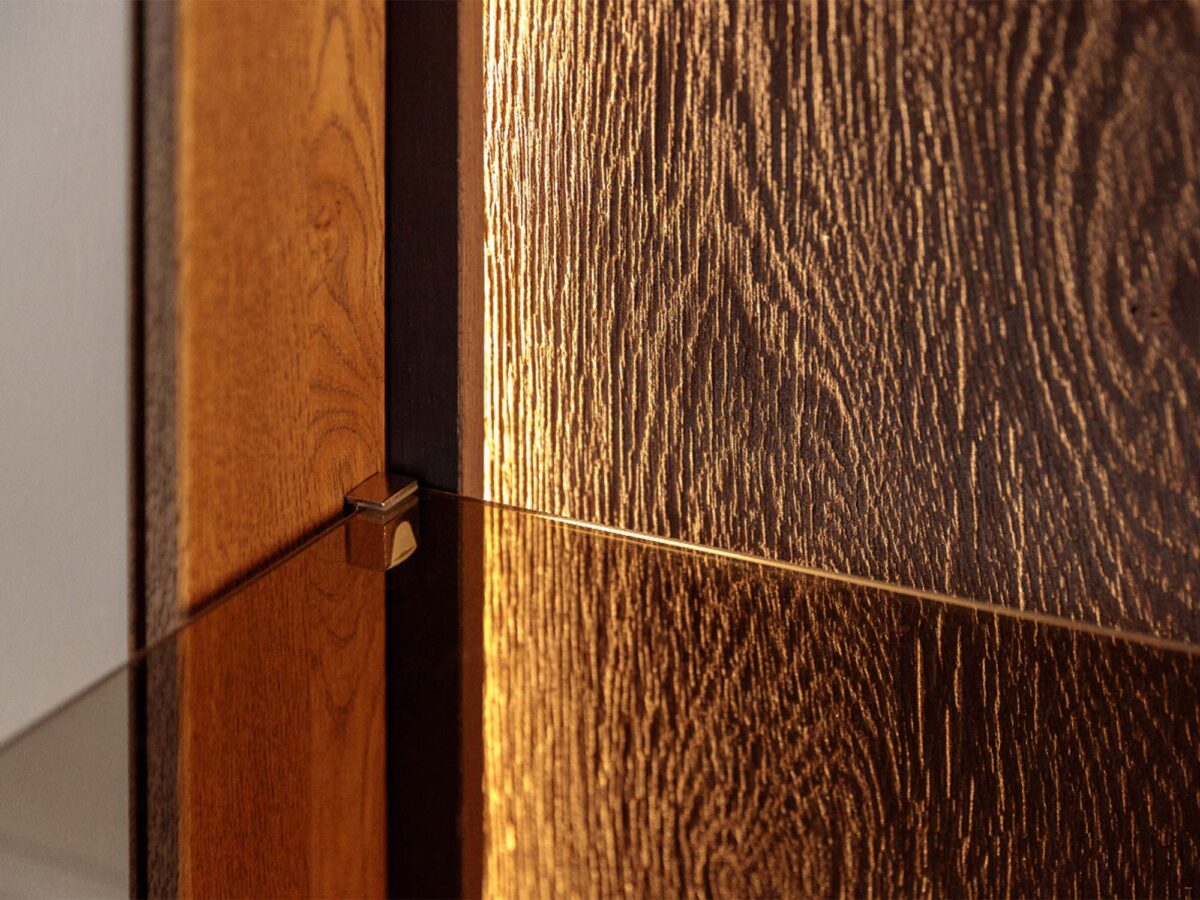 Detal drzwi komody tabacco z usłojeniem drewna i podpórką półki Detal drzwi komody tabacco z usłojeniem drewna i podpórką półki