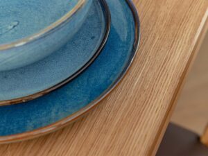 Miniaturka 5 - Detal narożnika blatu stołu dębowego z talerzami ceramicznymi