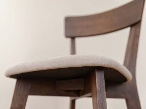 Miniaturka 3 - Detal tapicerowanego siedziska beżowego krzesła dębowego zbliżenie