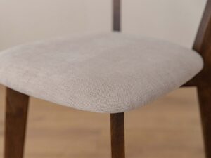 Miniaturka 4 - Detal tapicerowanego siedziska beżowego krzesła z widoczną fakturą tkaniny