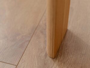 Miniaturka 11 - Detal nogi dębowej stolika kawowego na drewnianej podłodze zbliżenie