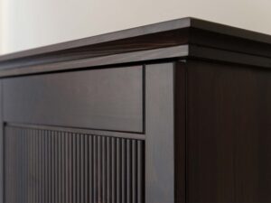 Miniaturka 4 - Detal narożnika szafki dwudrzwiowej drewnianej ciemnobrązowej z usłojeniem
