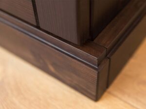 Miniaturka 7 - Detal górnego gzymsu szafy drewnianej ciemnobrązowej zbliżenie