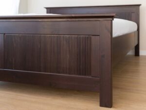 Miniaturka 1 - Detal nóżki i ramy łóżka drewnianego ciemnobrązowego z ryflowanym panelem
