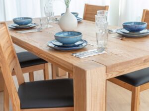 Miniaturka 2 - Detal narożnika blatu i nogi stołu drewnianego dębowego jasnego z zastawą