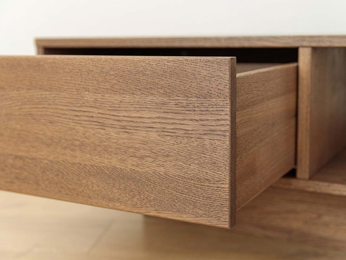 Detal cokołu i frontu szuflady stolika kawowego tabacco z usłojeniem