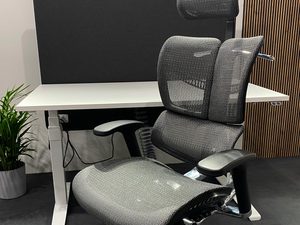 Miniaturka 3 - Szary fotel biurowy ergonomiczny siatkowy przy biurku perspektywa