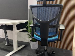 Miniaturka 1 - Fotel biurowy ergonomiczny niebieski siatkowy tył przy biurku