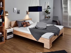 Miniaturka 11 - Bukowe łóżko z pościelą w szarej sypialni z regałem i lampą aranżacja