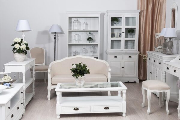 Salon prowansalski biały z witryną stolikiem i kremową sofą