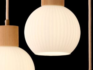Miniaturka 10 - Detal świecącego ryflowanego klosza lampy Alba 3 koło na ciemnym tle.