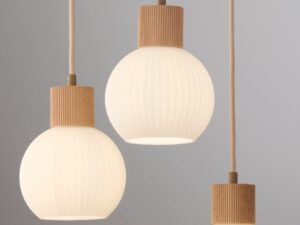Miniaturka 7 - Zbliżenie na trzy świecące ryflowane klosze lampy Alba 3 koło na szarym tle.