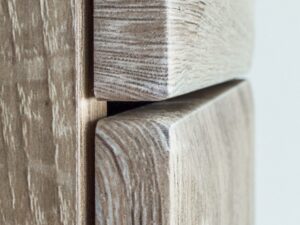 Miniaturka 5 - Garderoba z szafą słupkiem i panelem tapicerowanym Arvello 210 cm dąb Sonoma – Drewniana szafka w kolorze jasnego drewna z widoczną strukturą