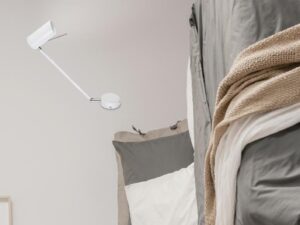 Miniaturka 2 - Biały kinkiet Goriveta przy łóżku w bocznym ujęciu sypialni