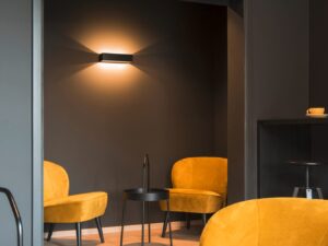 Miniaturka 2 - Kinkiet Logs In L LED czarno-złoty w salonie z musztardowymi fotelami
