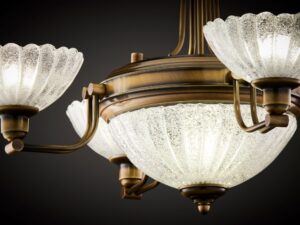 Miniaturka 4 - Lampa Carmen – zbliżenie ryflowanego szkła i metalowych ramion w antycznym mosiądzu