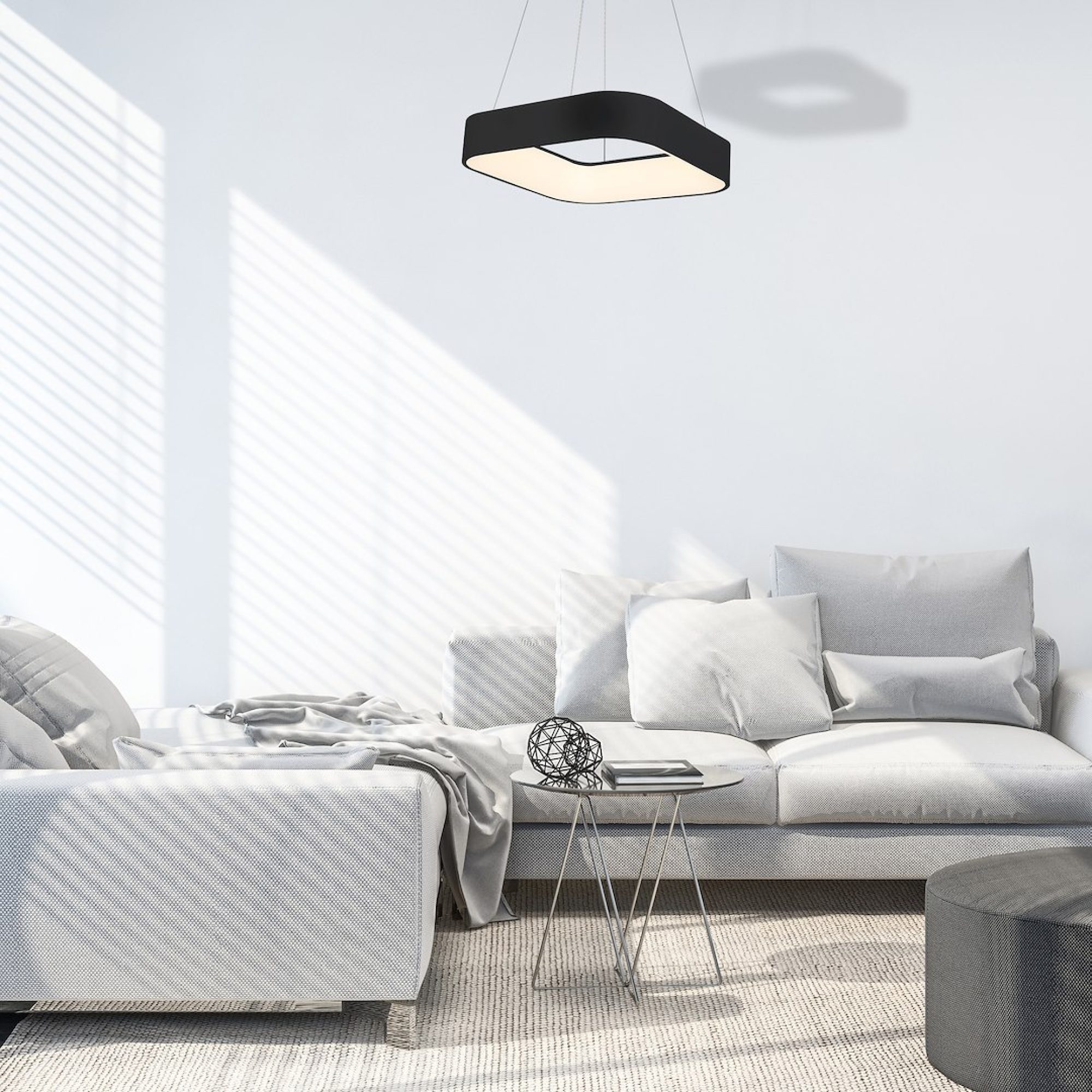 Lampa Elemina czarna zawieszona nad sofą w jasnym salonie