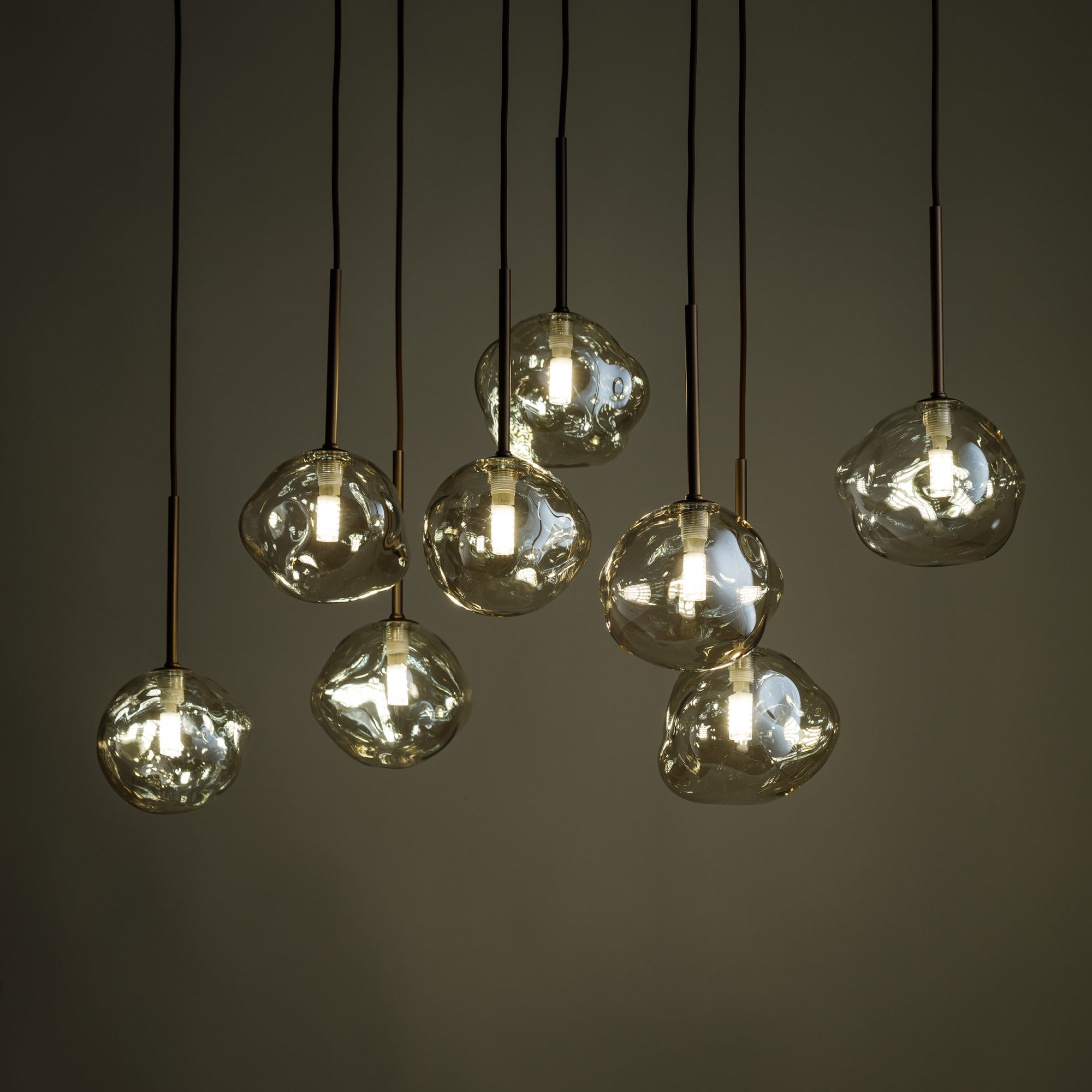 Brązowa lampa Lava z rozświetlonymi kloszami na ciemnym tle