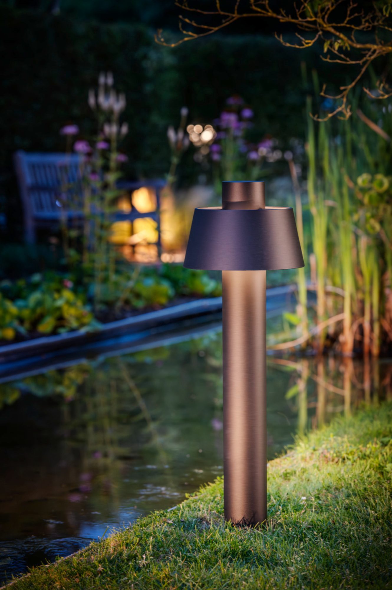 Czarna lampa Photoni Cyl Pole 75 w aranżacji ogrodu
